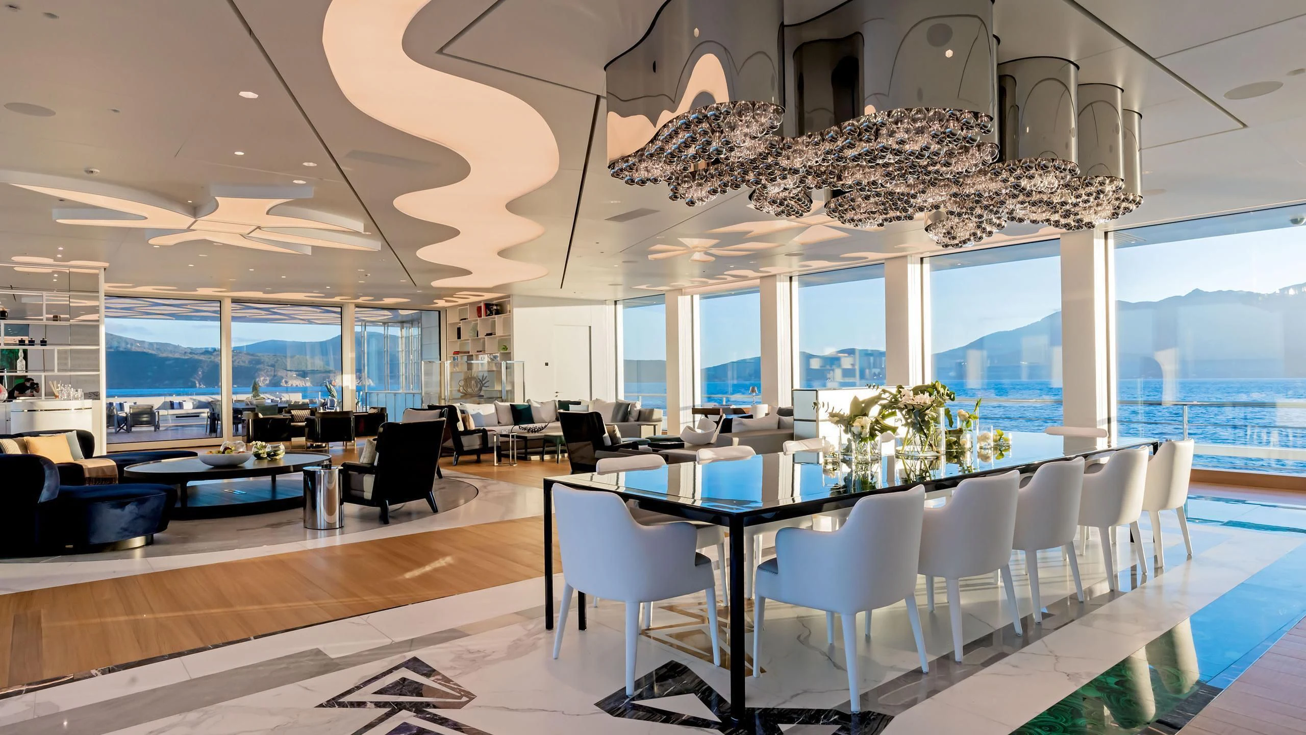 a room with tables and chairs aboard LUMINOSITY Yacht for Sale