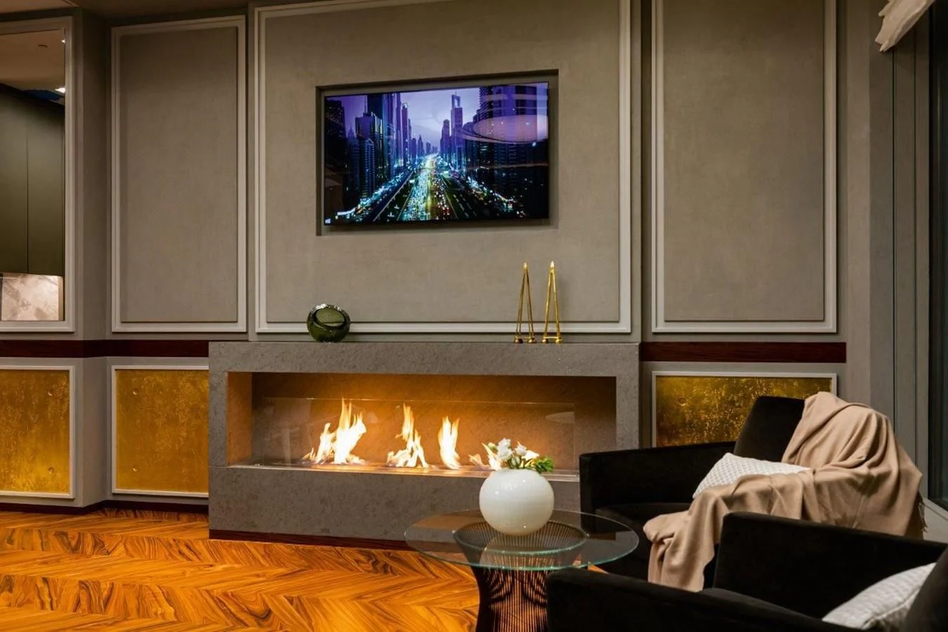 a fireplace with a glass table and a television on the wall aboard LUMINOSITY Yacht for Sale