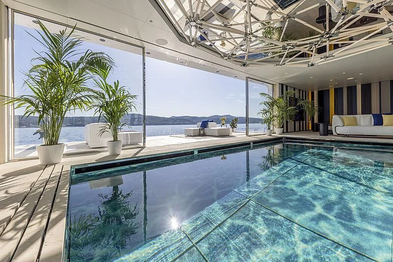 a swimming pool with plants and a view of the ocean aboard LUMINOSITY Yacht for Sale