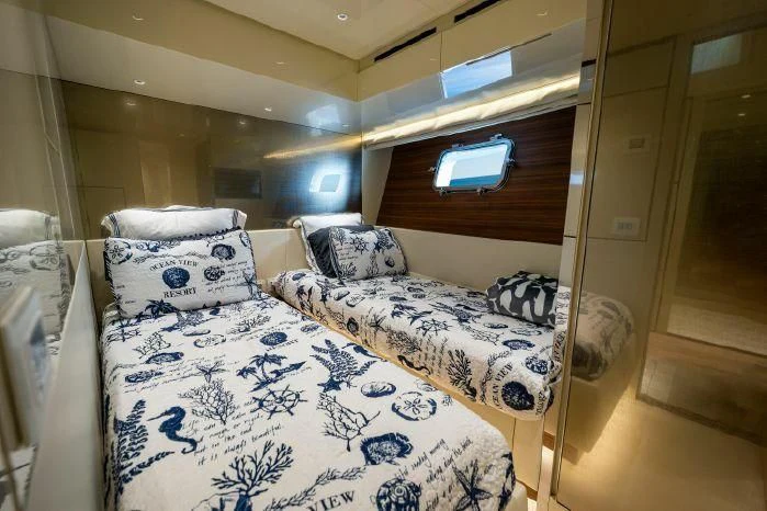 a bed with a blue and white comforter and pillows aboard ABOUT TIME Yacht for Sale