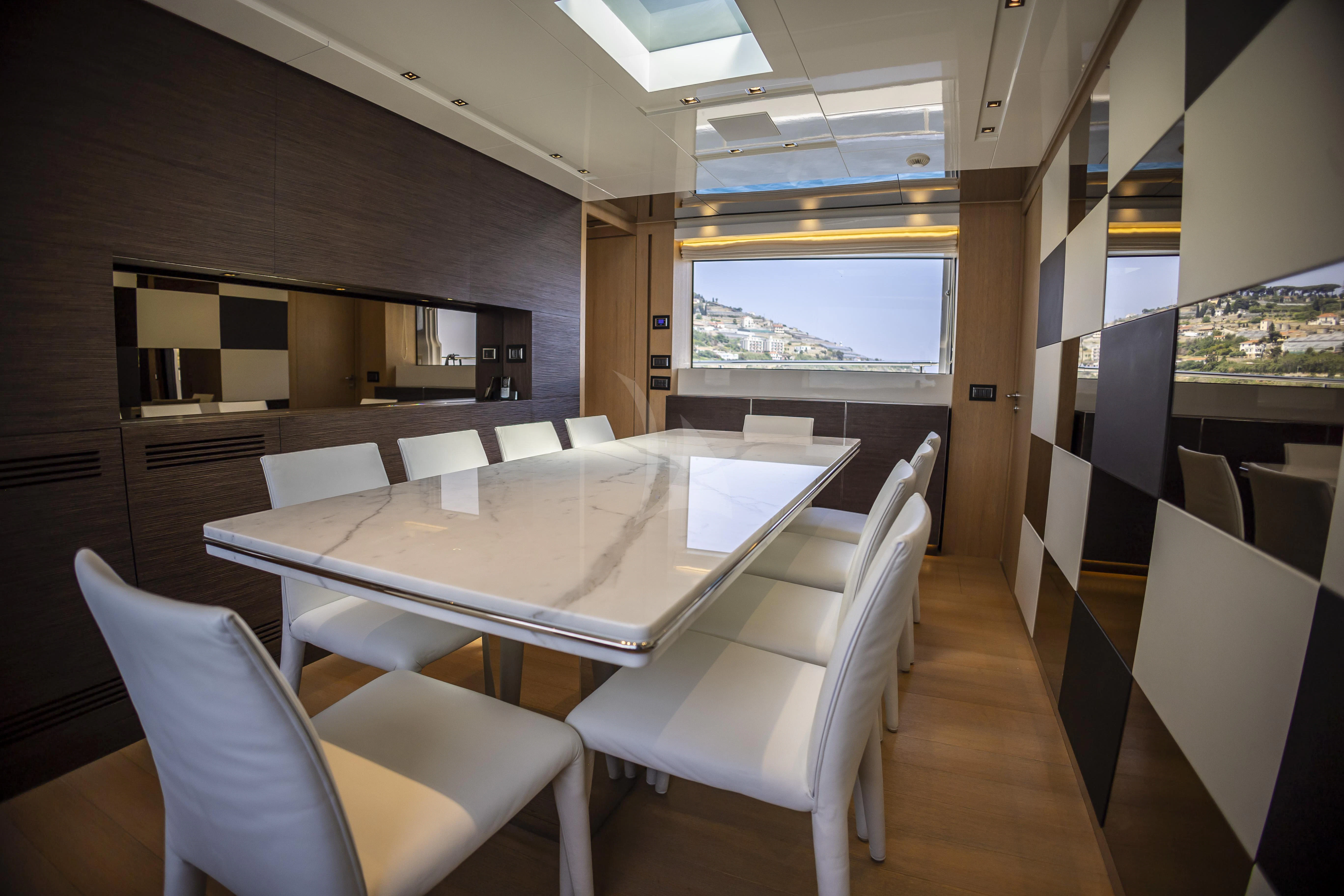 a room with a table and chairs aboard AMAN Yacht for Sale