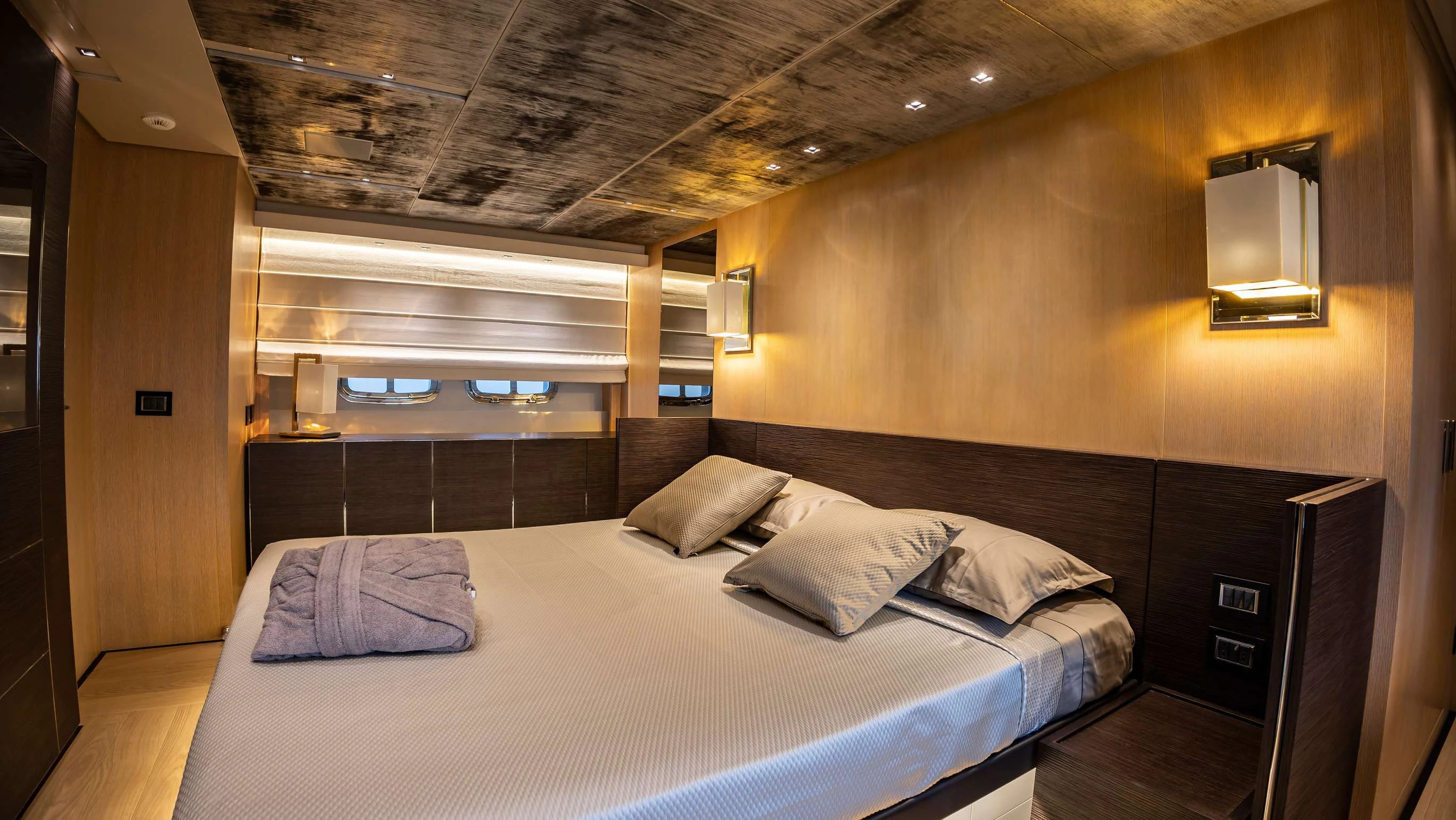 a room with a bed and a mirror aboard AMAN Yacht for Sale