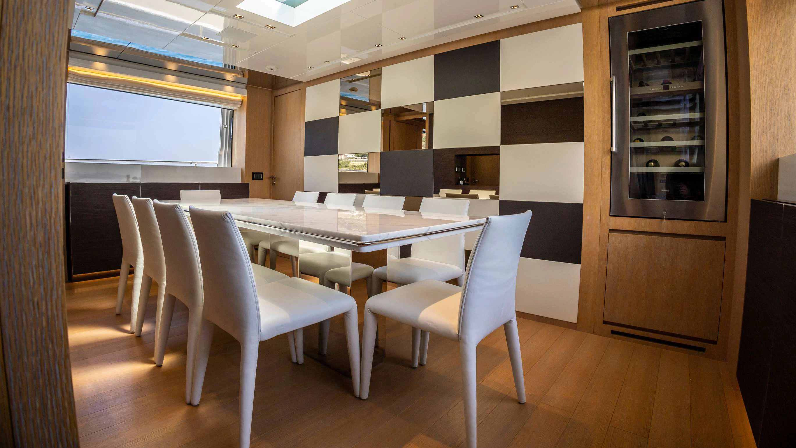 a room with a table chairs and cabinets aboard AMAN Yacht for Sale