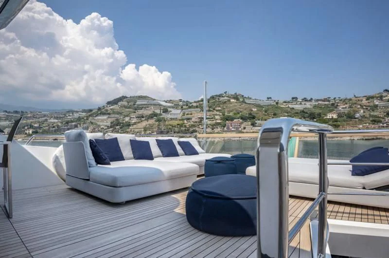 a deck with chairs and a view of a city aboard AMAN Yacht for Sale