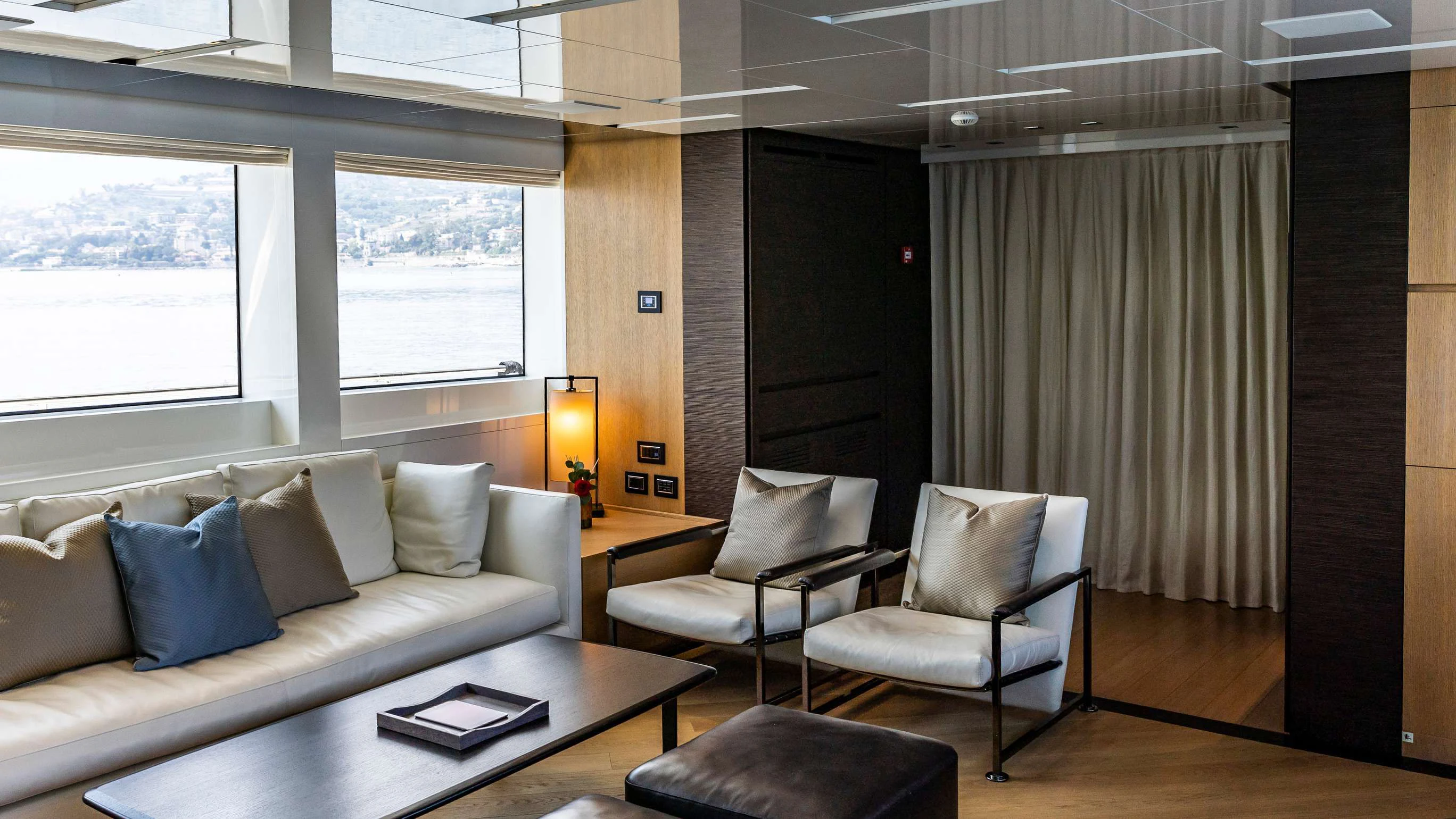 a room with a couch and a table aboard AMAN Yacht for Sale