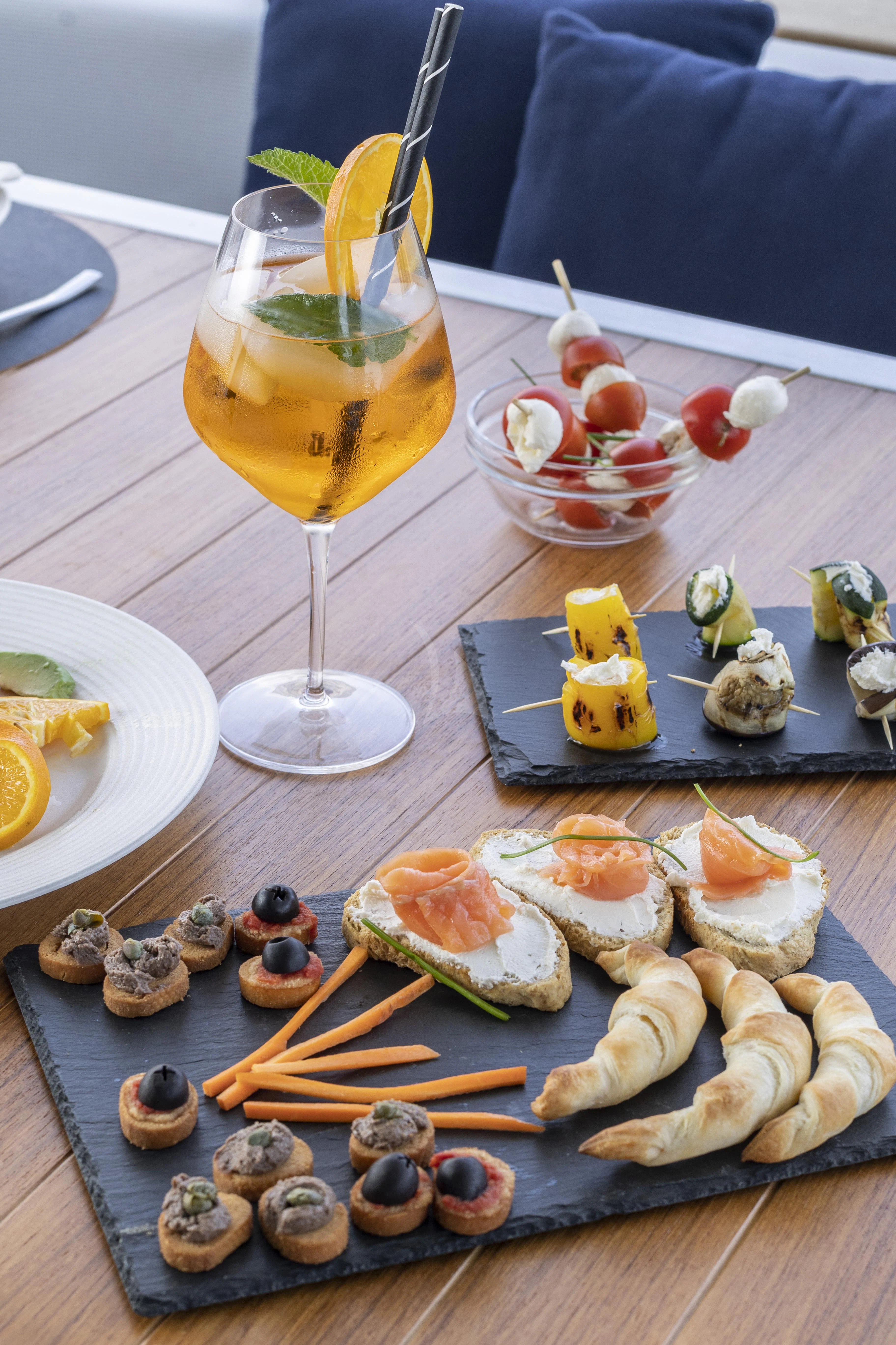 a table with food and drinks on it aboard AMAN Yacht for Sale