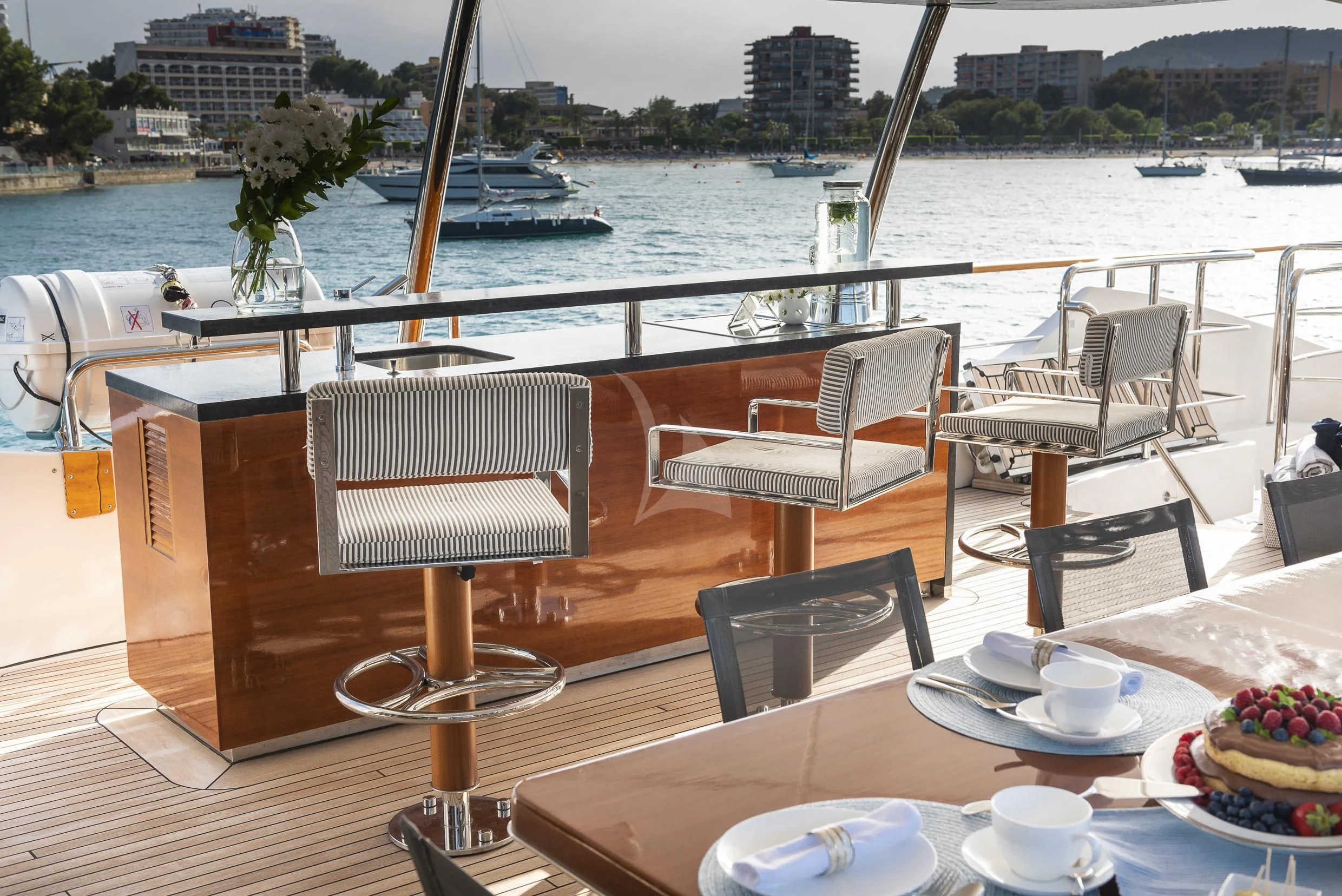 a table with chairs on it next to a body of water aboard ORSO 3 Yacht for Sale