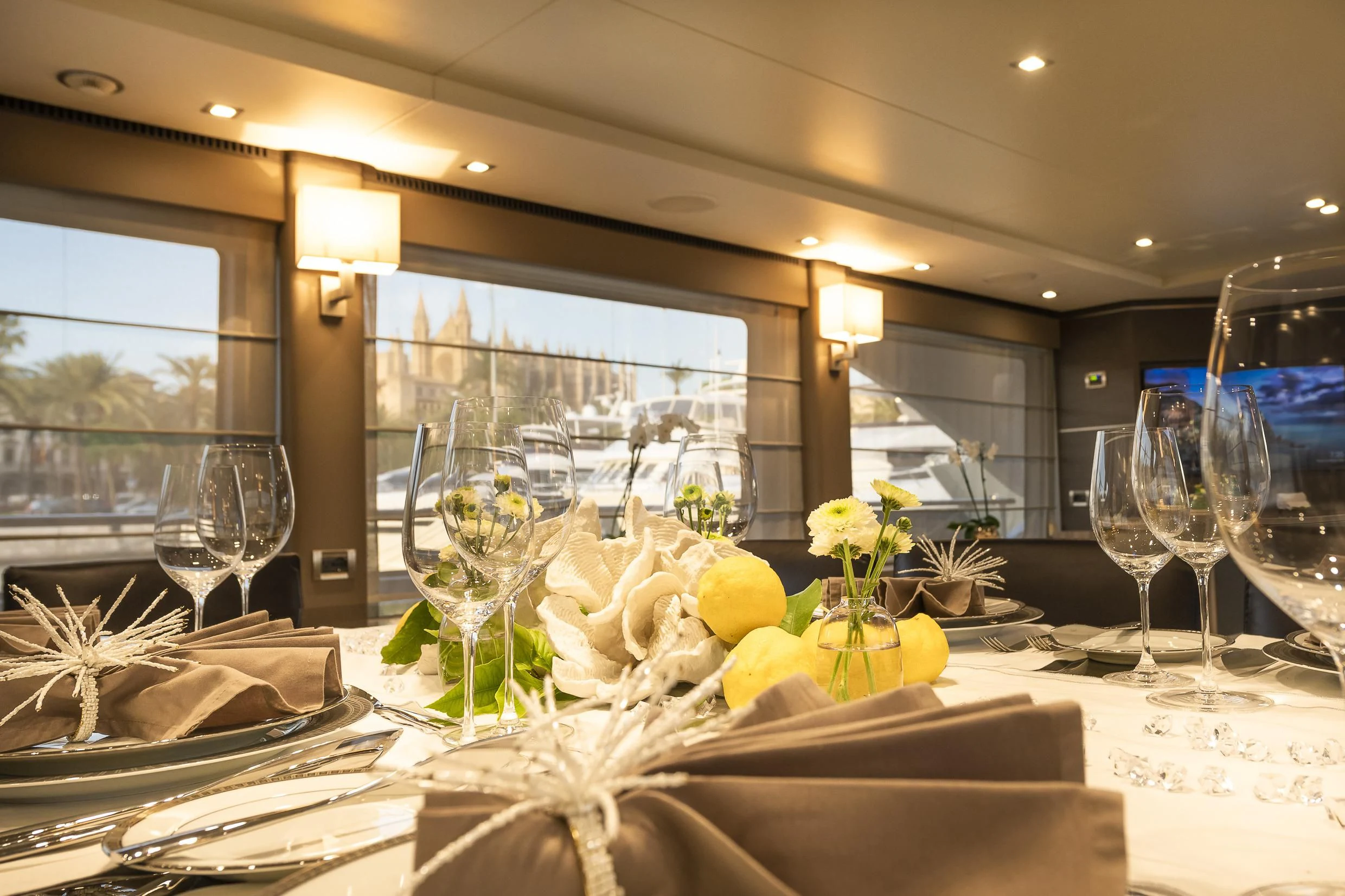 a table with wine glasses and flowers aboard ORSO 3 Yacht for Sale