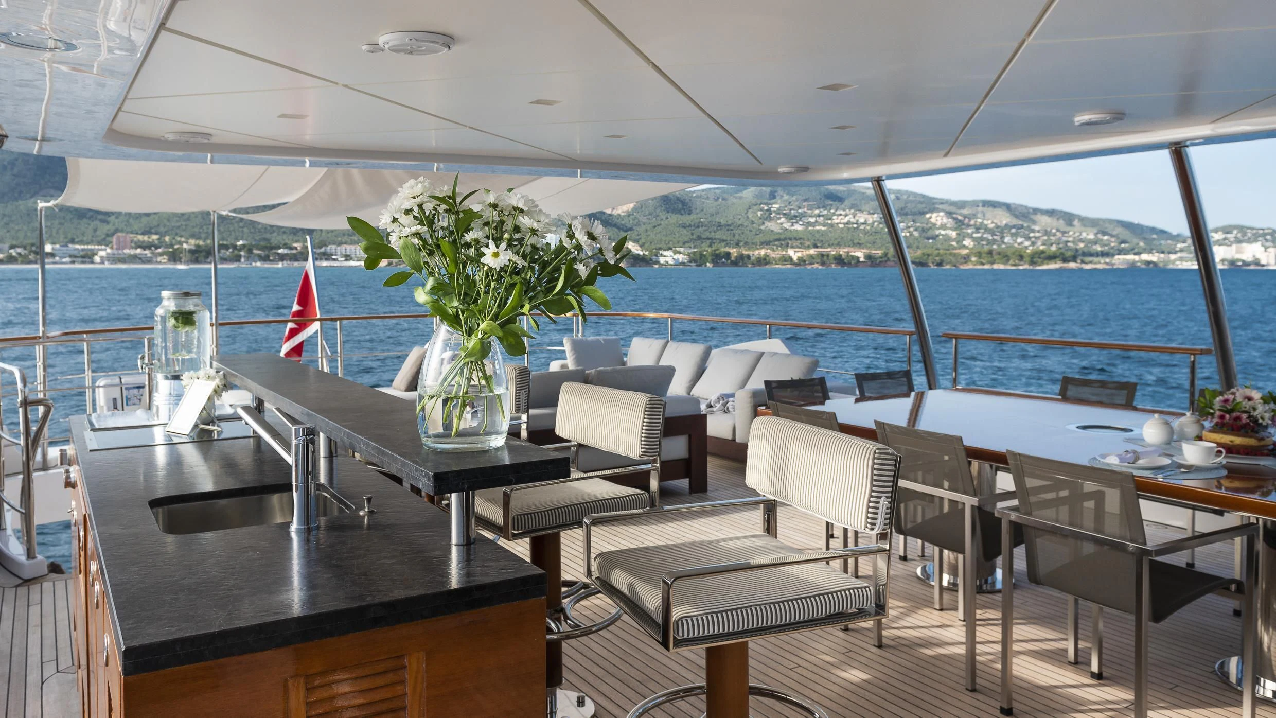 a table with chairs and a plant on it aboard ORSO 3 Yacht for Sale