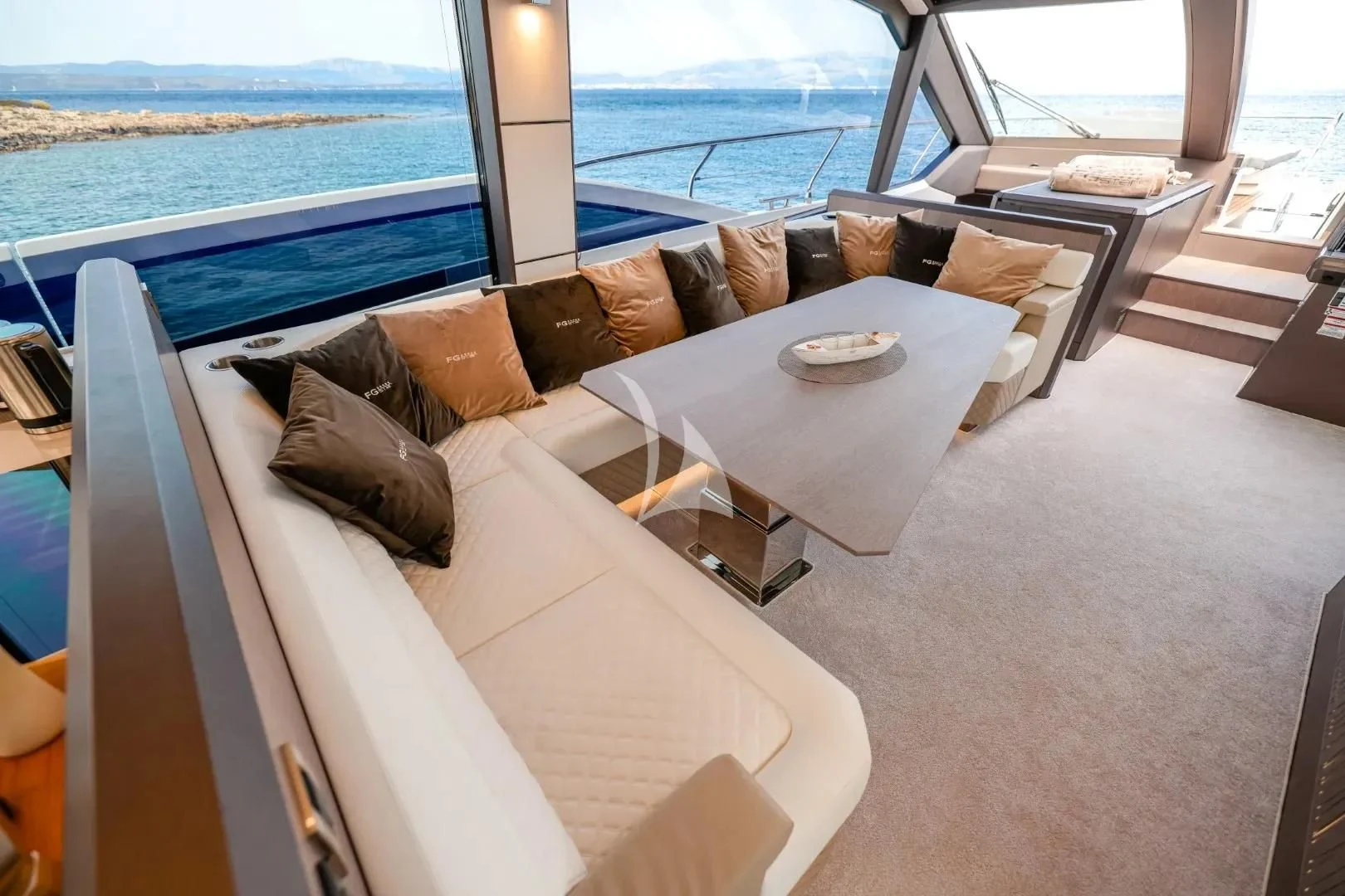 a couch and a table in a room with a view of the ocean aboard FG STAR Yacht for Charter