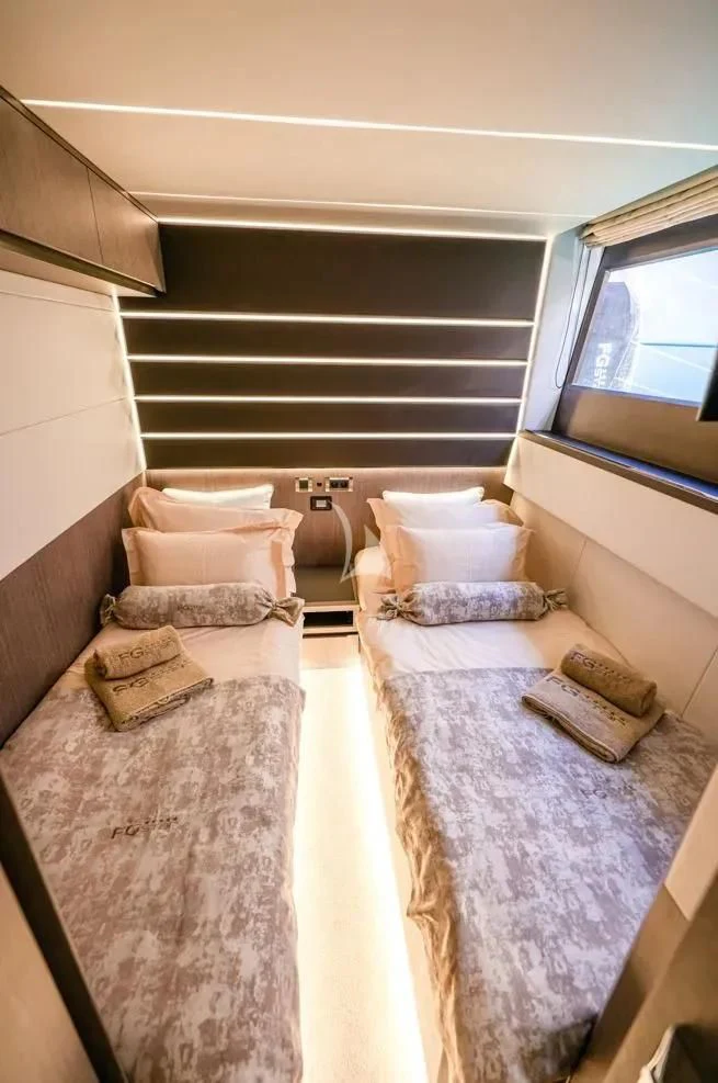 a small bedroom with a bed and a couch aboard FG STAR Yacht for Charter