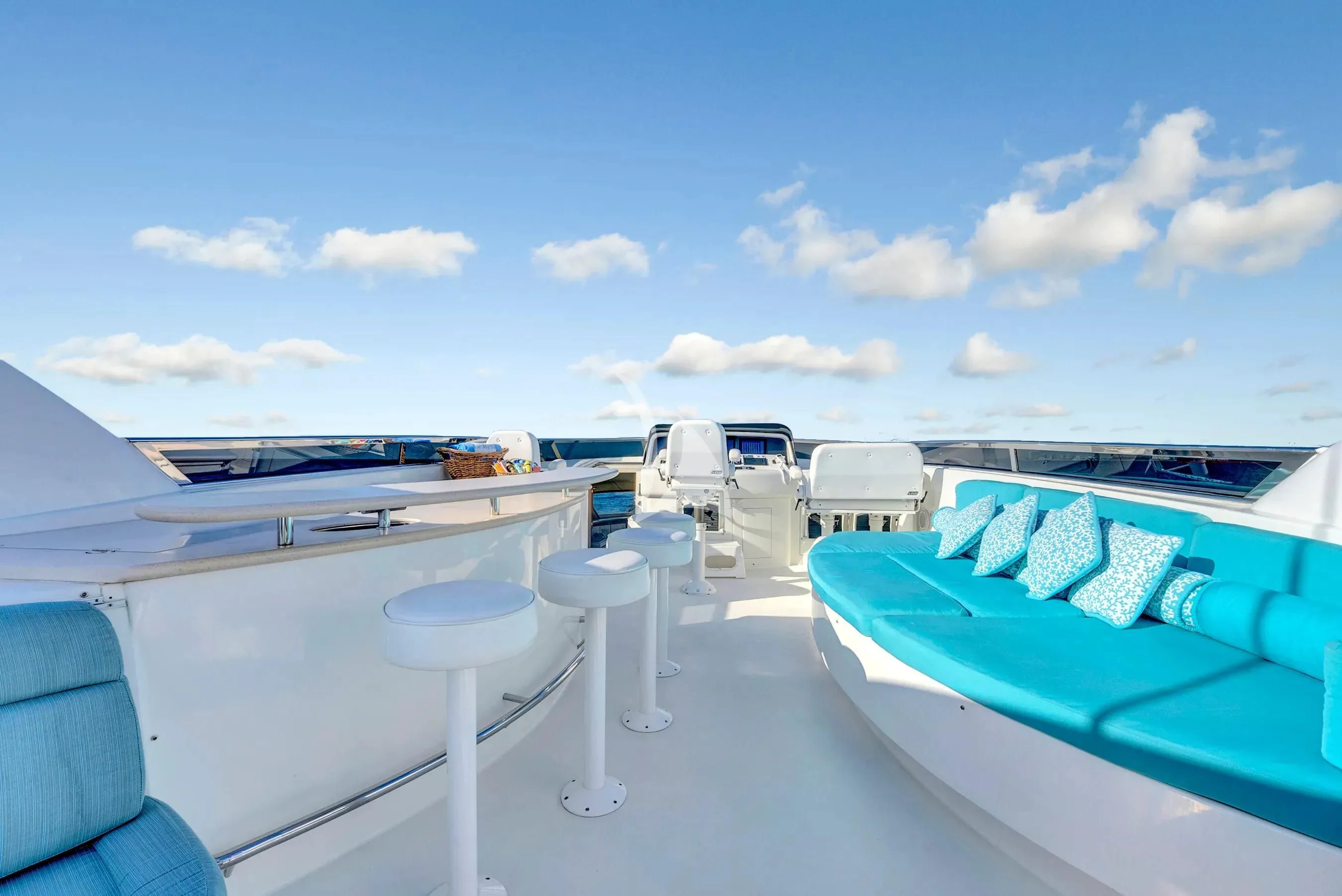 a pool and lounge chairs on a deck with a blue sky and clouds aboard LE REVE Yacht for Sale