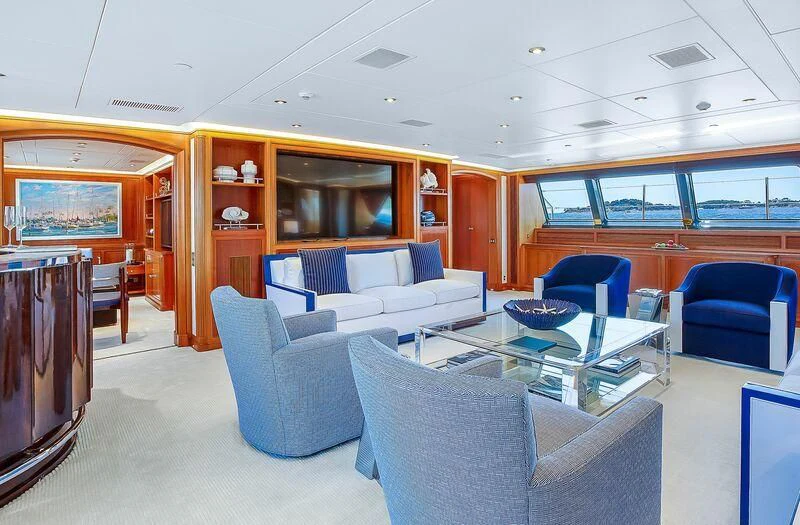 a living room with blue chairs and a table aboard ZENJI Yacht for Sale