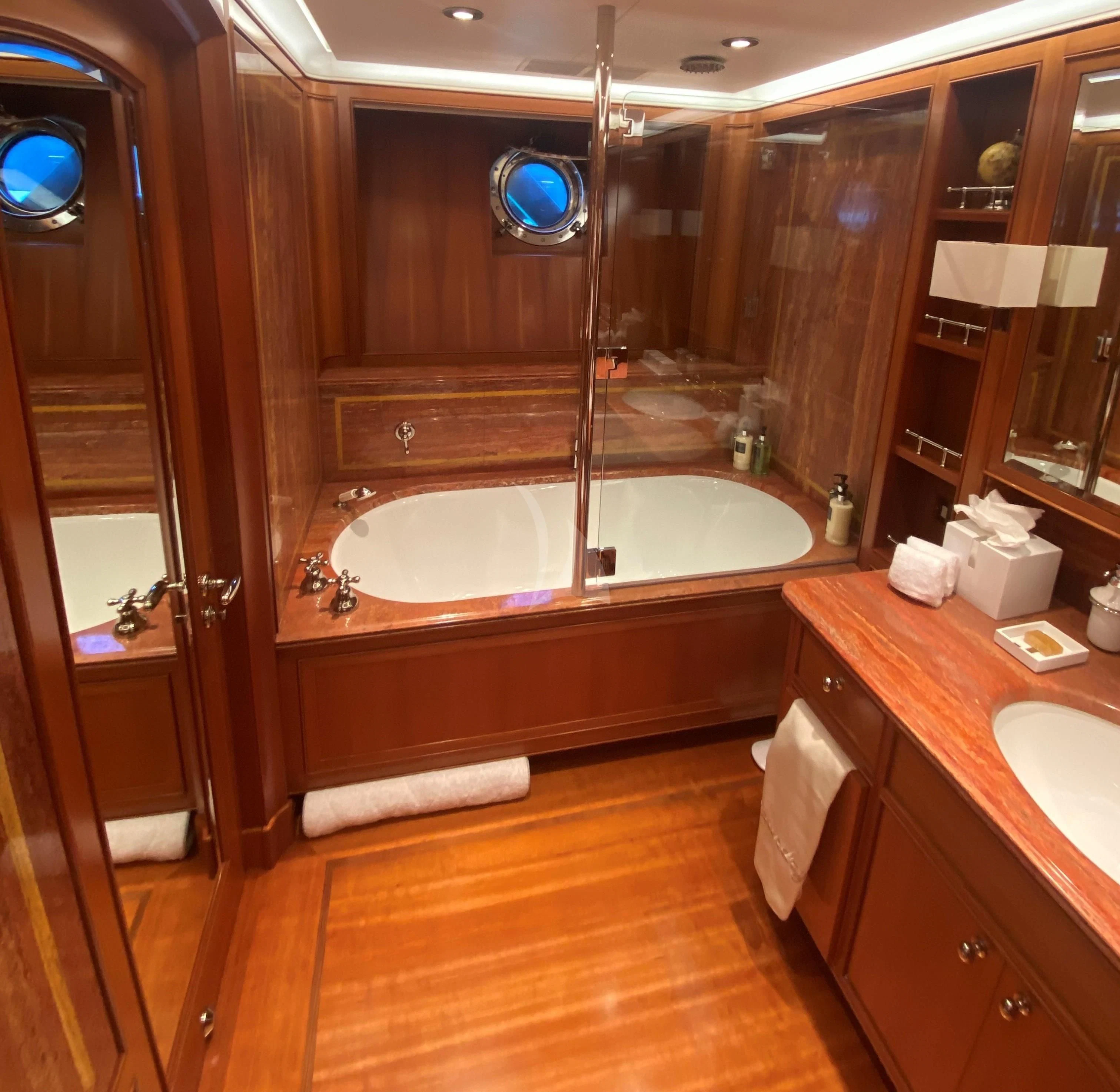 a bathroom with a tub sink and mirror aboard ZENJI Yacht for Sale