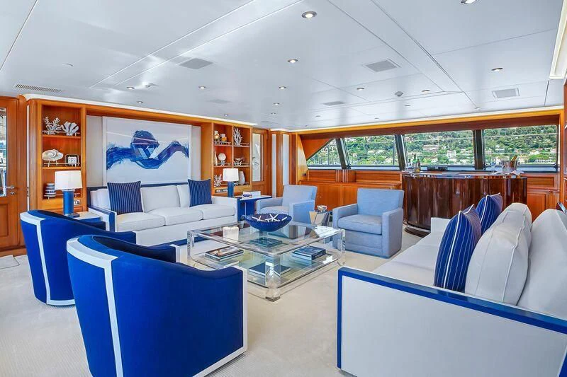 a room with blue chairs and tables aboard ZENJI Yacht for Sale