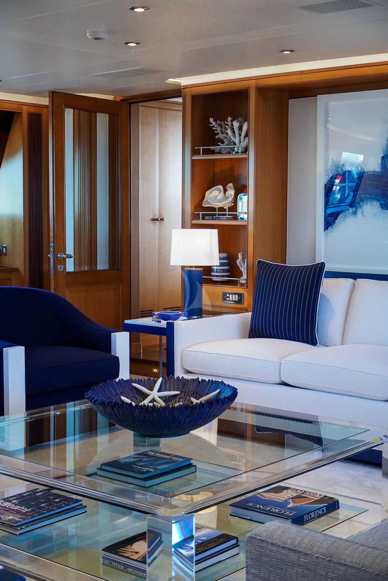 a living room with a blue couch and a coffee table aboard ZENJI Yacht for Sale