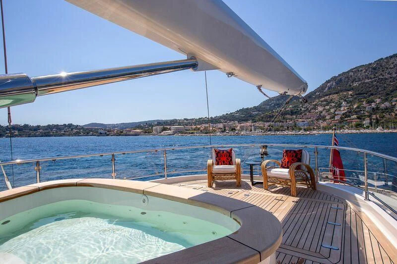 a deck with chairs and a body of water in the background aboard ZENJI Yacht for Sale
