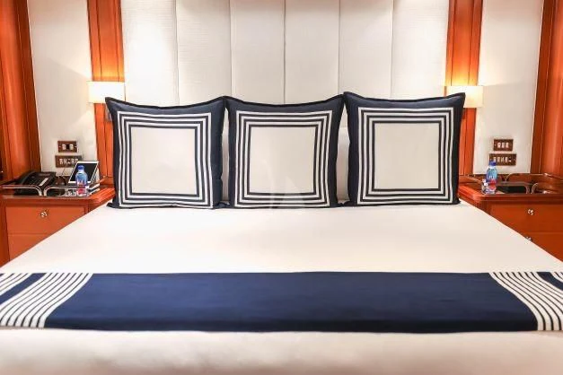 a bed with a white sheet and black sheets aboard ZENJI Yacht for Sale