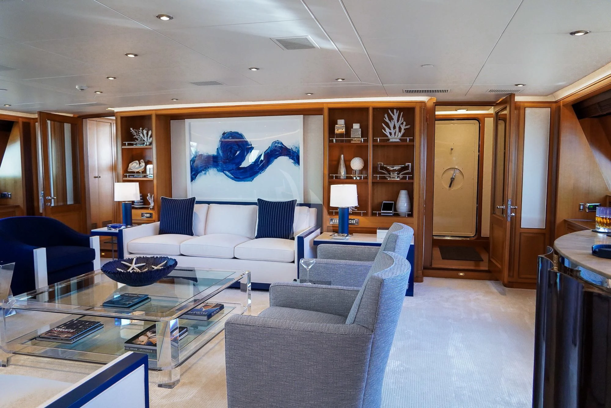 a living room with a blue couch aboard ZENJI Yacht for Sale