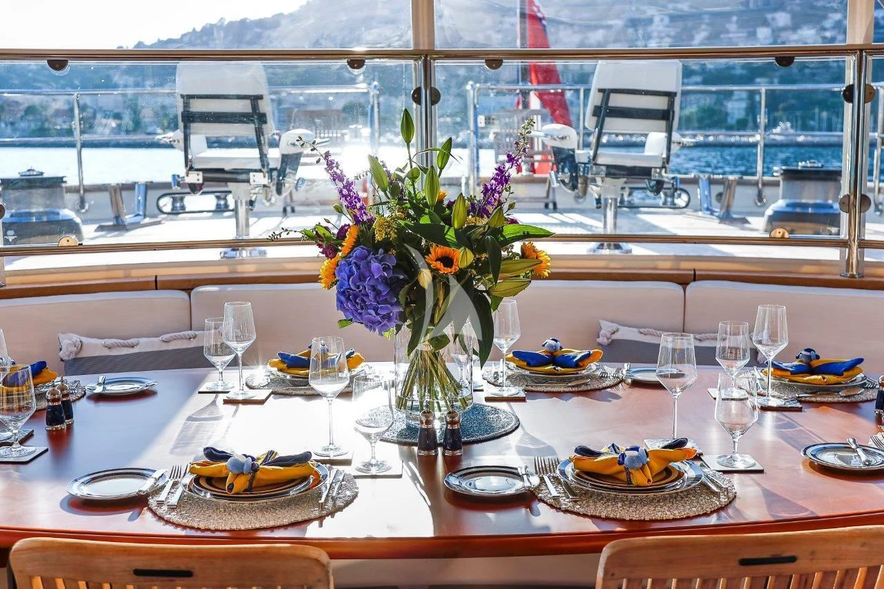 a table with plates and flowers aboard ZENJI Yacht for Sale