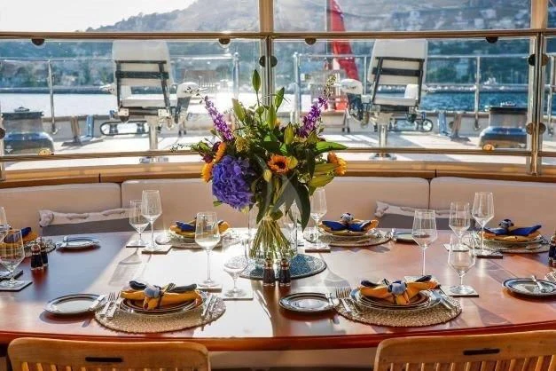 a table with food and flowers aboard ZENJI Yacht for Sale