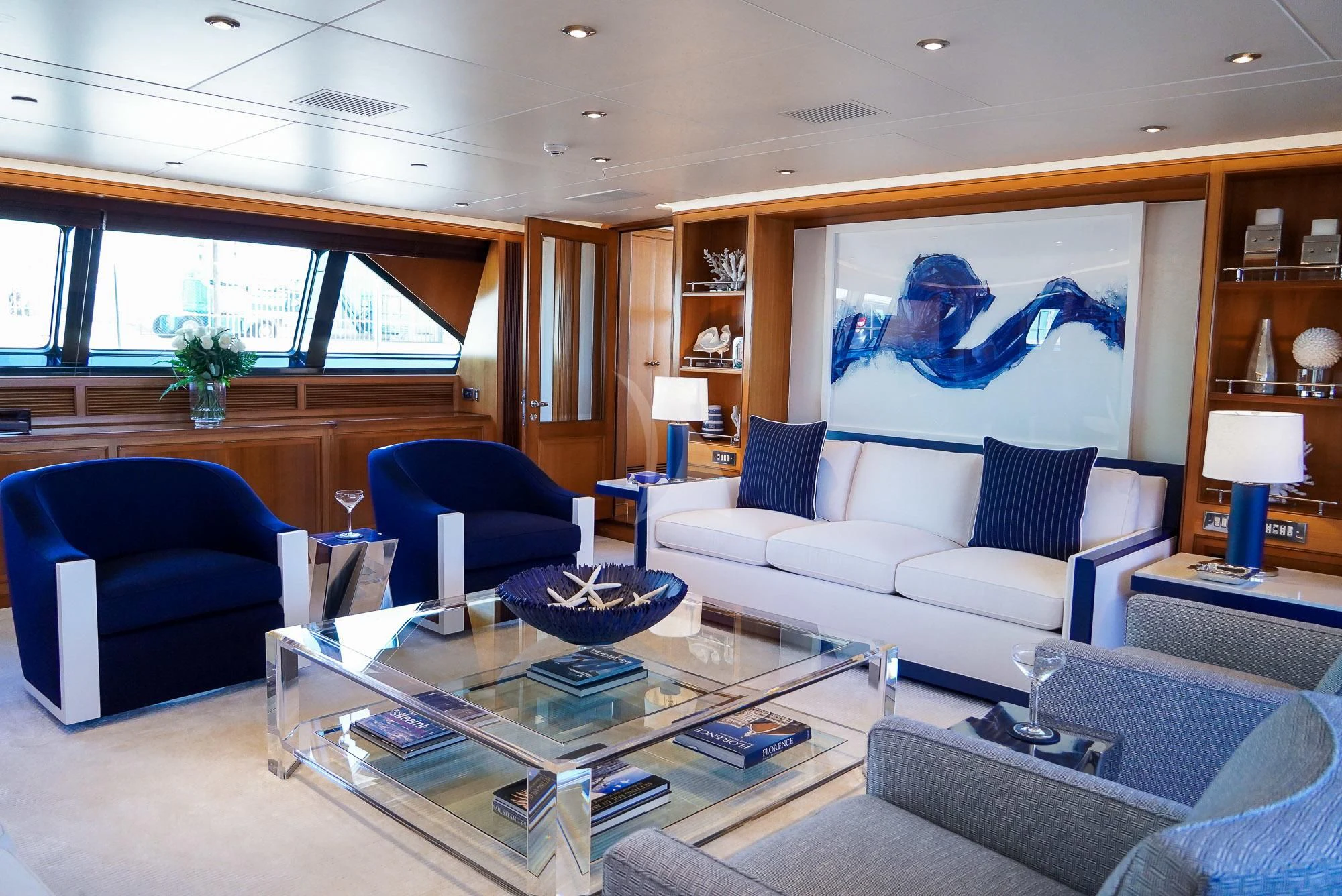 a living room with a blue couch and a coffee table aboard ZENJI Yacht for Sale