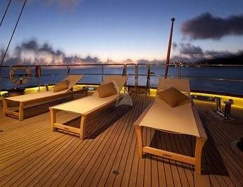 a deck with a view of the ocean and a boat on it aboard ZENJI Yacht for Sale
