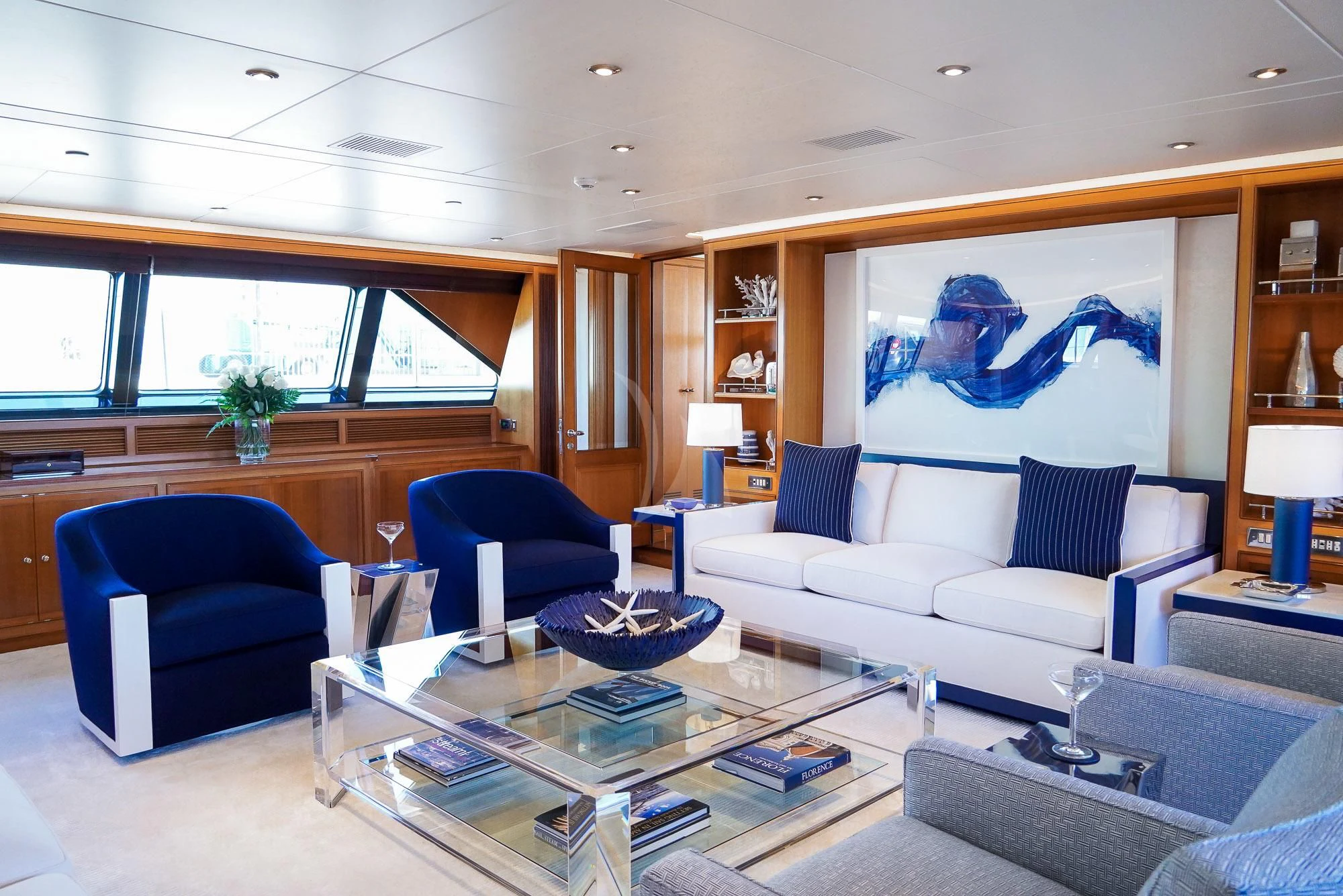 a living room with a blue couch and a large painting aboard ZENJI Yacht for Sale