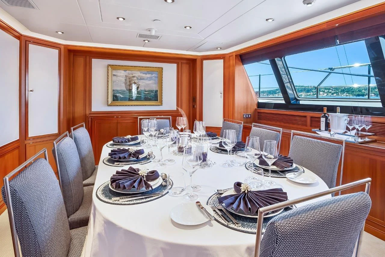 a dining room with a table set aboard ZENJI Yacht for Sale