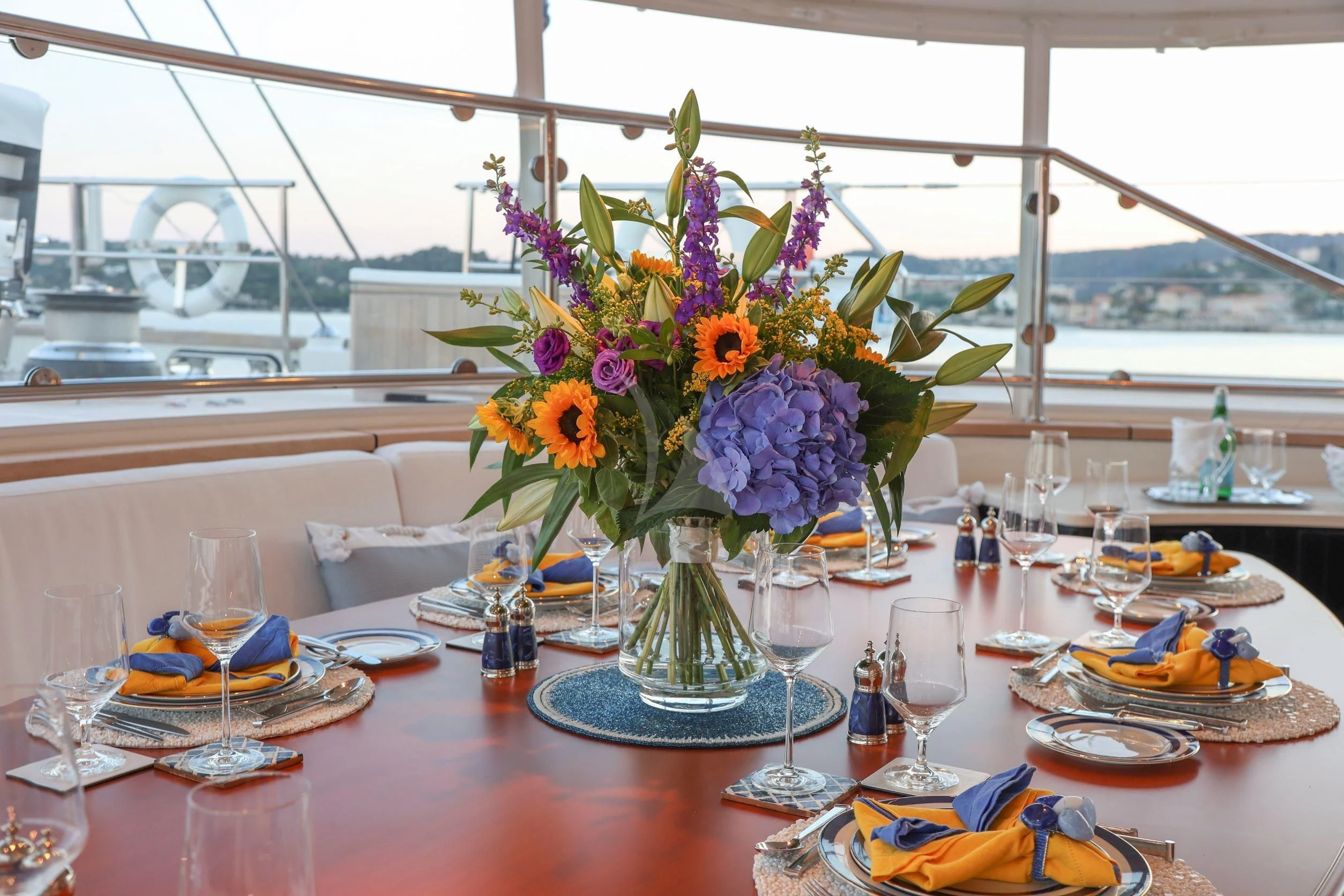a table with flowers and plates aboard ZENJI Yacht for Sale