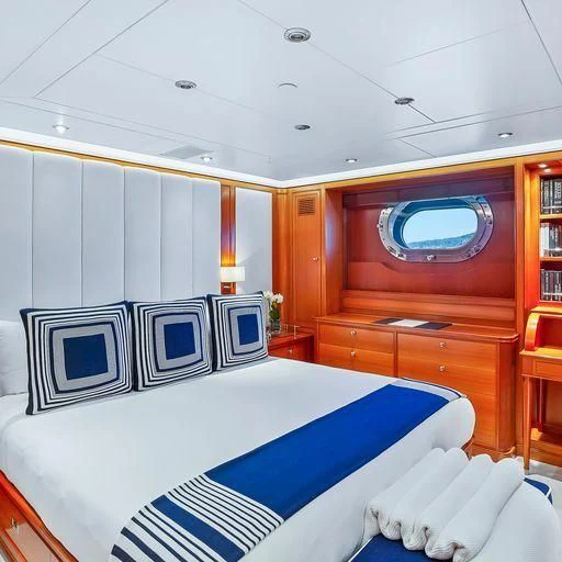 a room with a bed and a desk aboard ZENJI Yacht for Sale