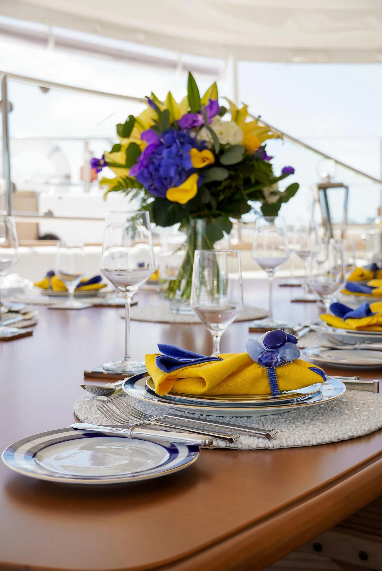 a table with a plate of flowers and glasses on it aboard ZENJI Yacht for Sale