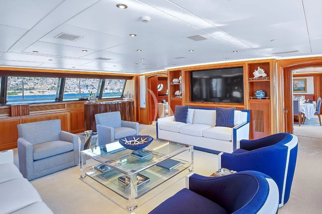 a living room with blue couches aboard ZENJI Yacht for Sale