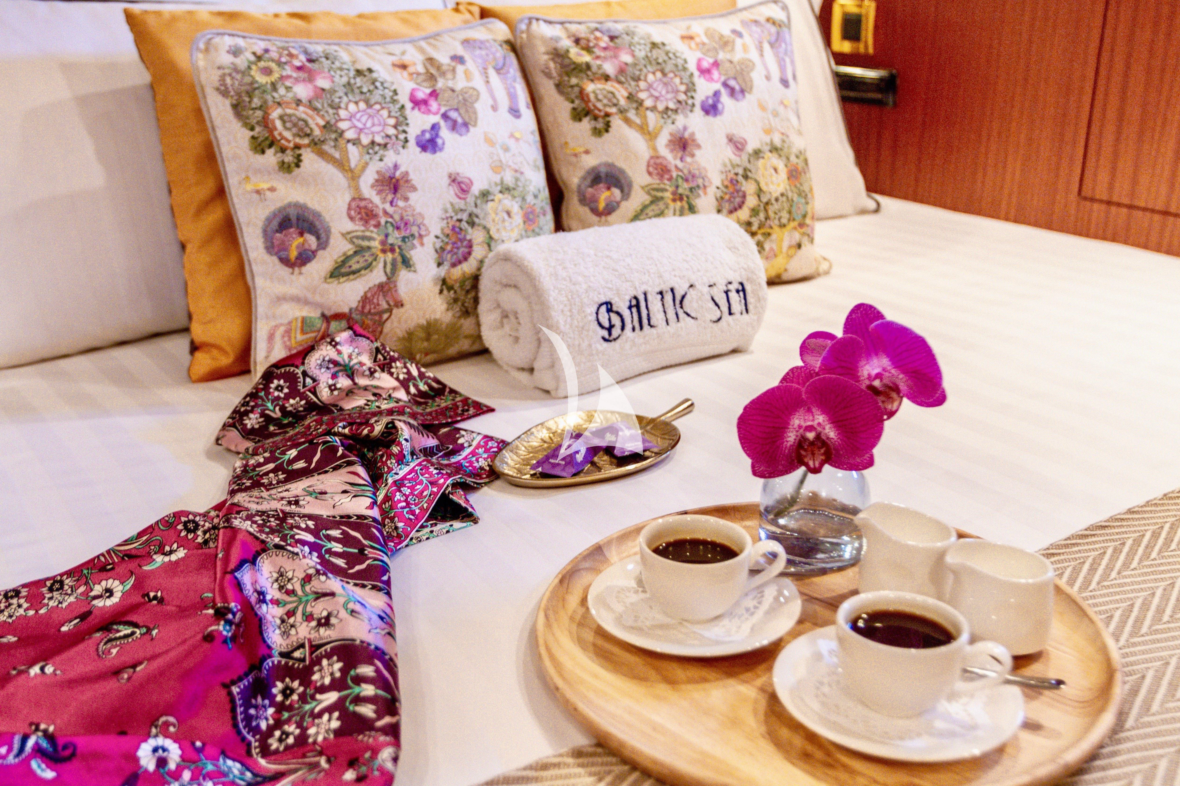 a table with a plate of coffee and a flower on it aboard BALTIC SEA Yacht for Sale