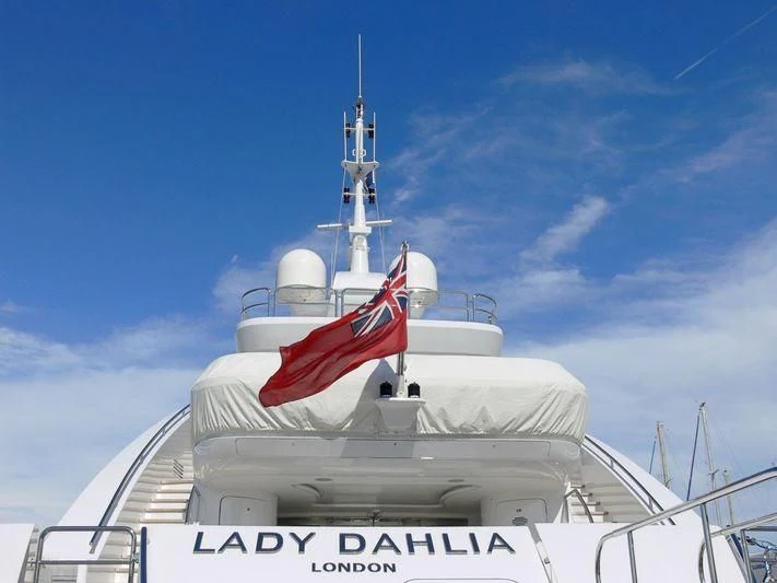 a white boat with a red flag on it aboard ALALYA Yacht for Sale