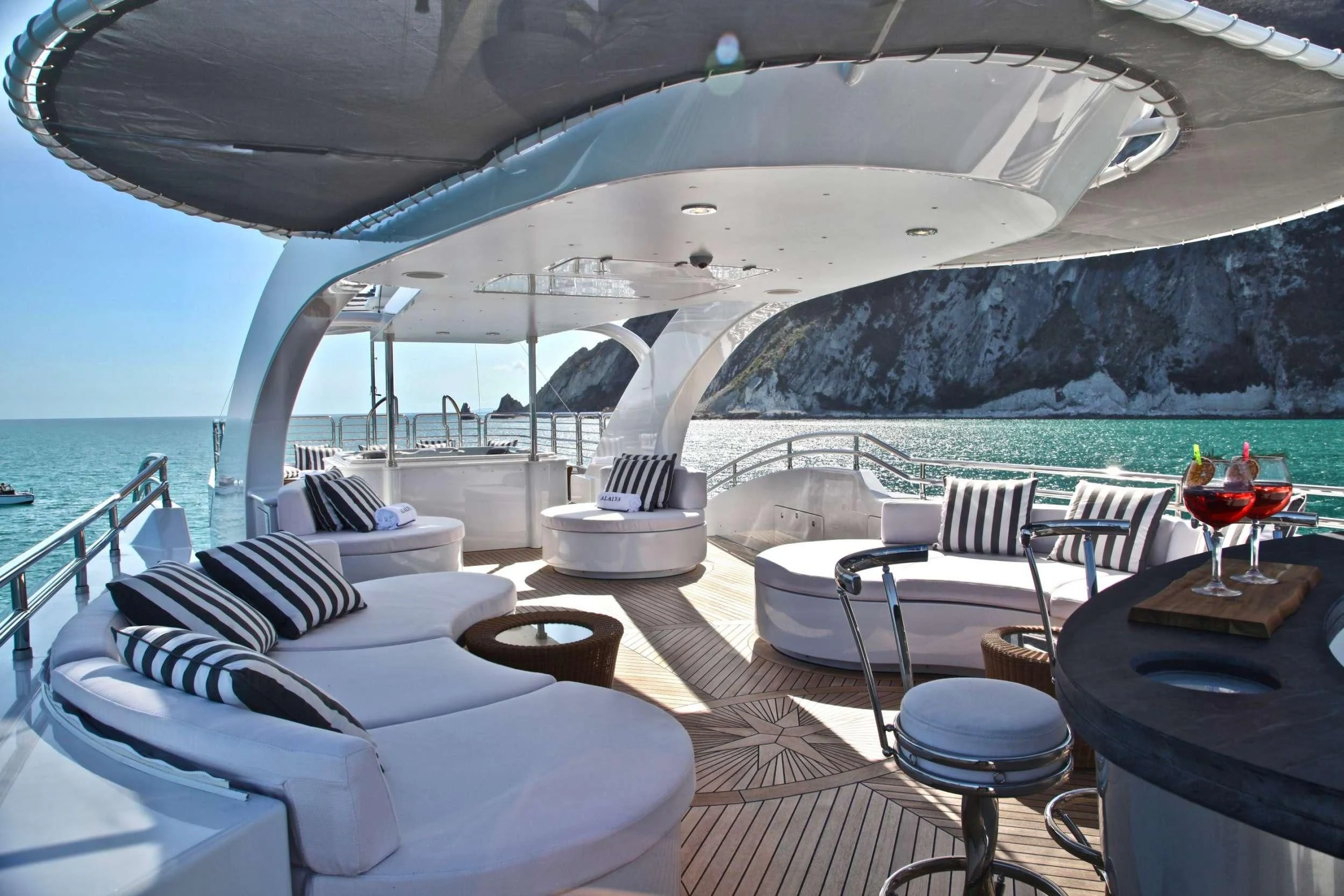 a room with a glass of wine and a view of the ocean aboard ALALYA Yacht for Sale