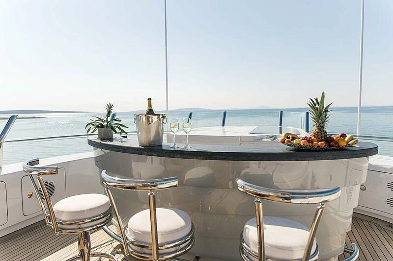 a table with chairs and a view of the ocean aboard ALALYA Yacht for Sale