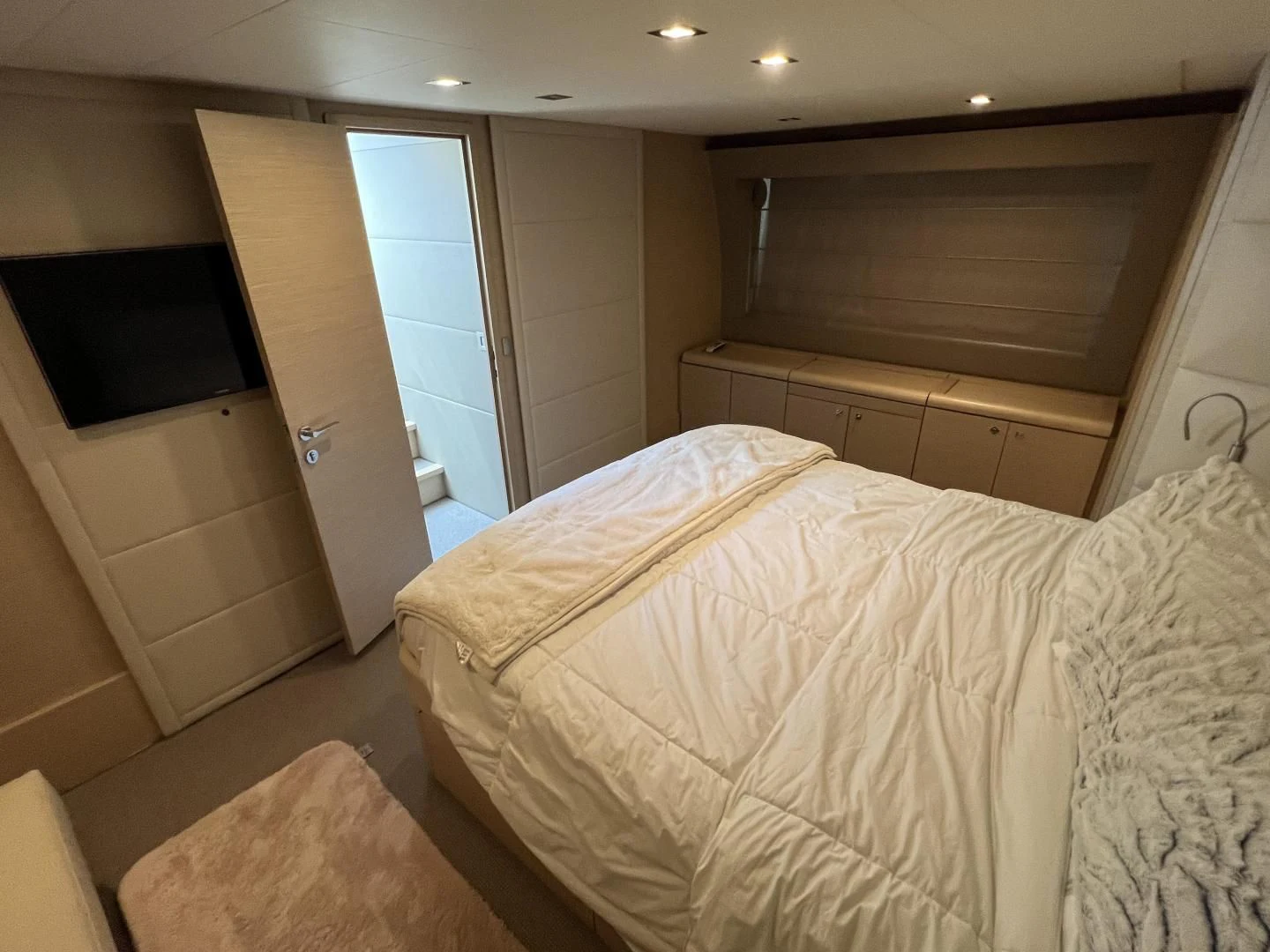a room with a bed and a television aboard FERRETTI Yacht for Sale