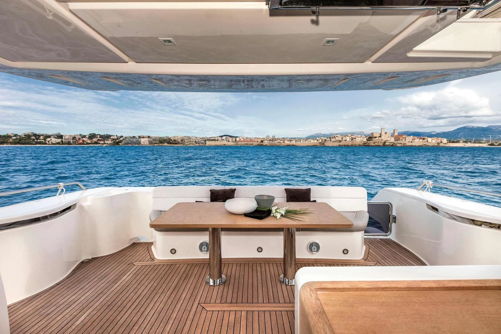 a table and chairs on a deck overlooking a large body of water aboard FERRETTI Yacht for Sale