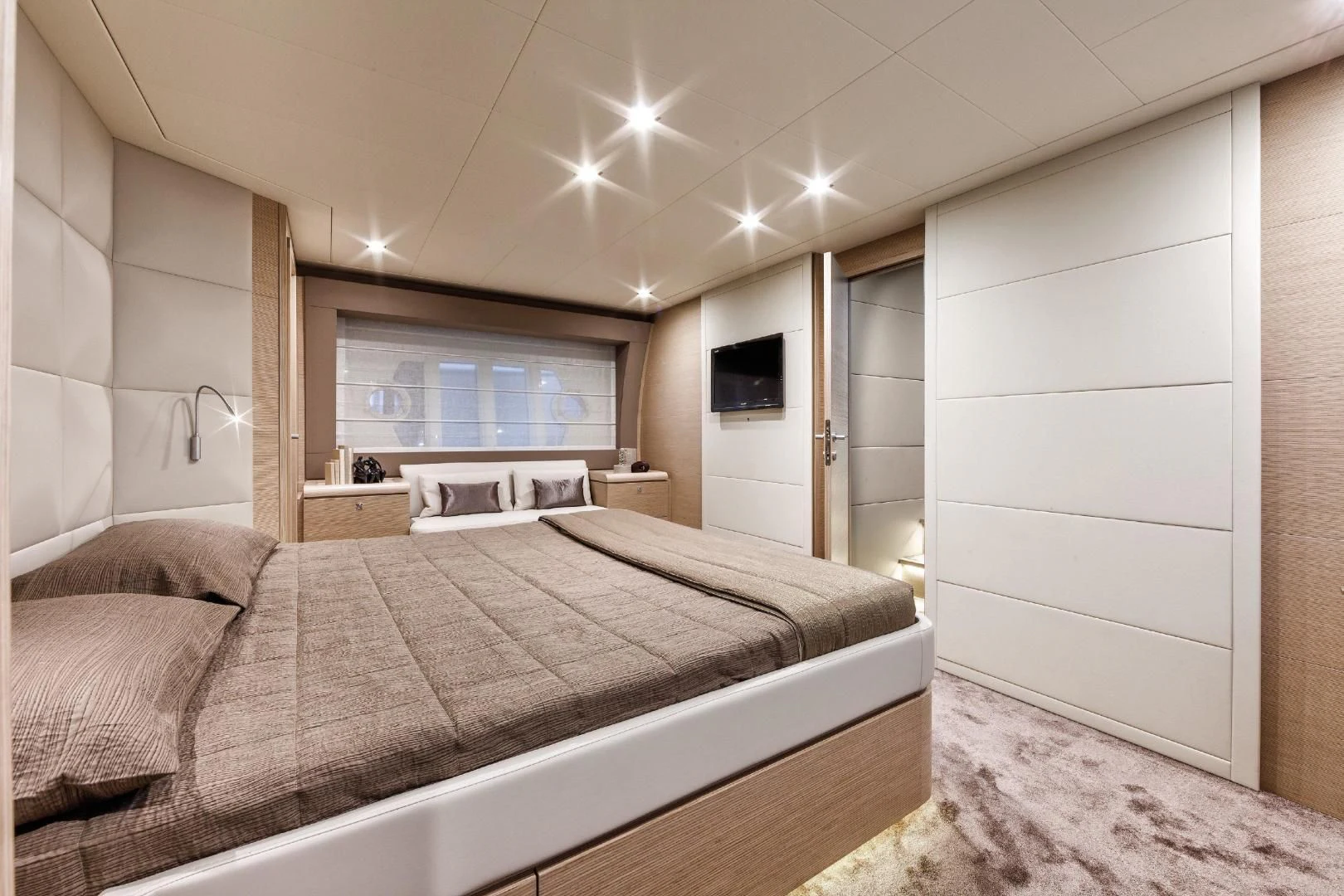 a bedroom with a bed and a television aboard FERRETTI Yacht for Sale