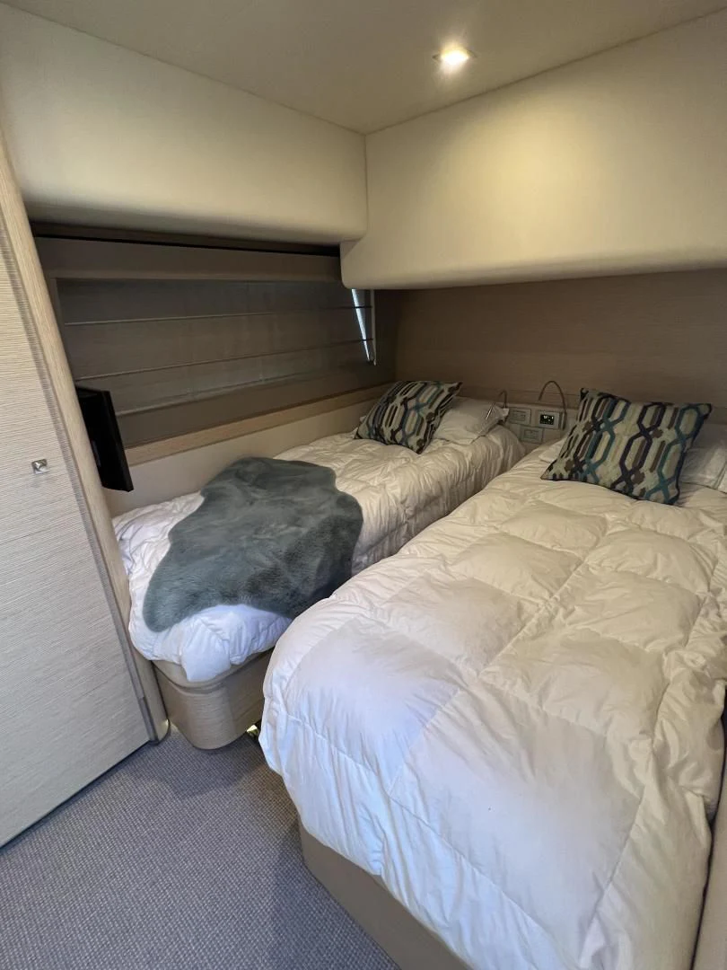 a bed with a white comforter aboard FERRETTI Yacht for Sale