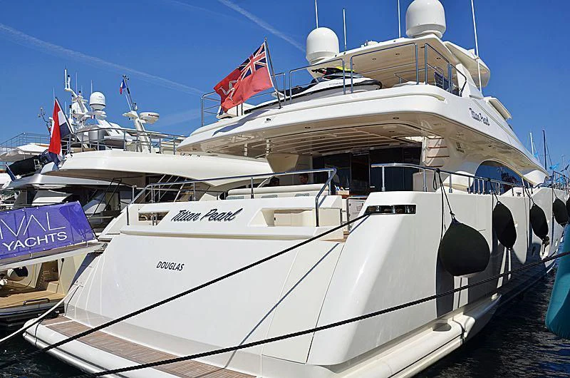 a large white boat with flags aboard THINK BIG Yacht for Sale