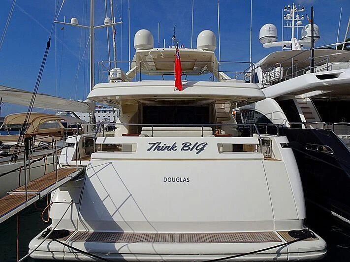 a white yacht in a harbor aboard THINK BIG Yacht for Sale