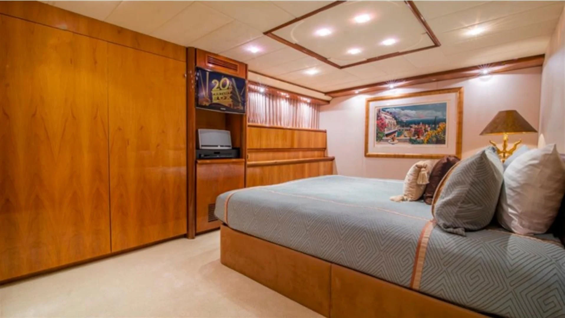 a bedroom with a bed and a wood cabinet aboard SHALIMAR Yacht for Sale