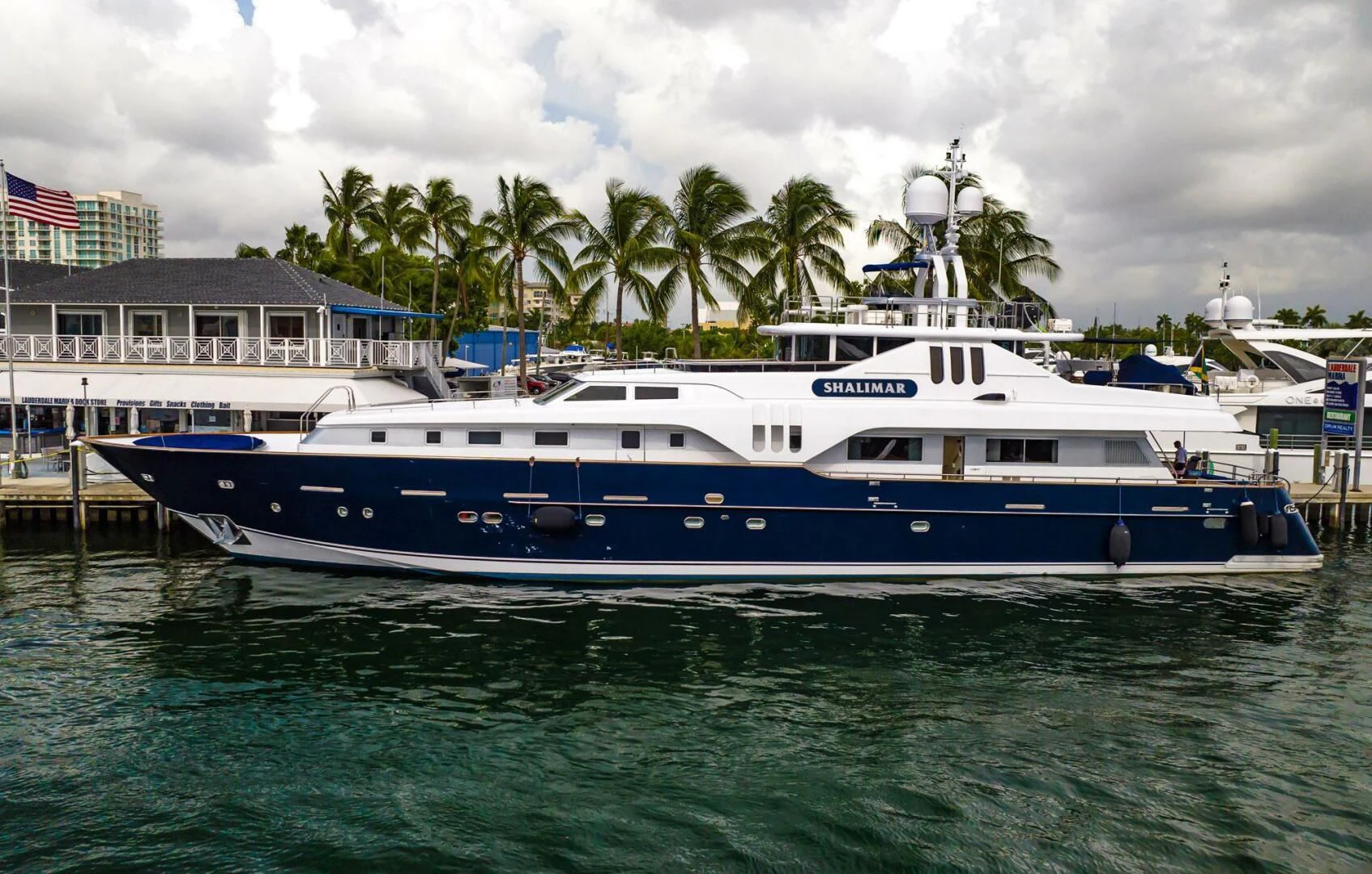 a large white boat in a harbor aboard SHALIMAR Yacht for Sale