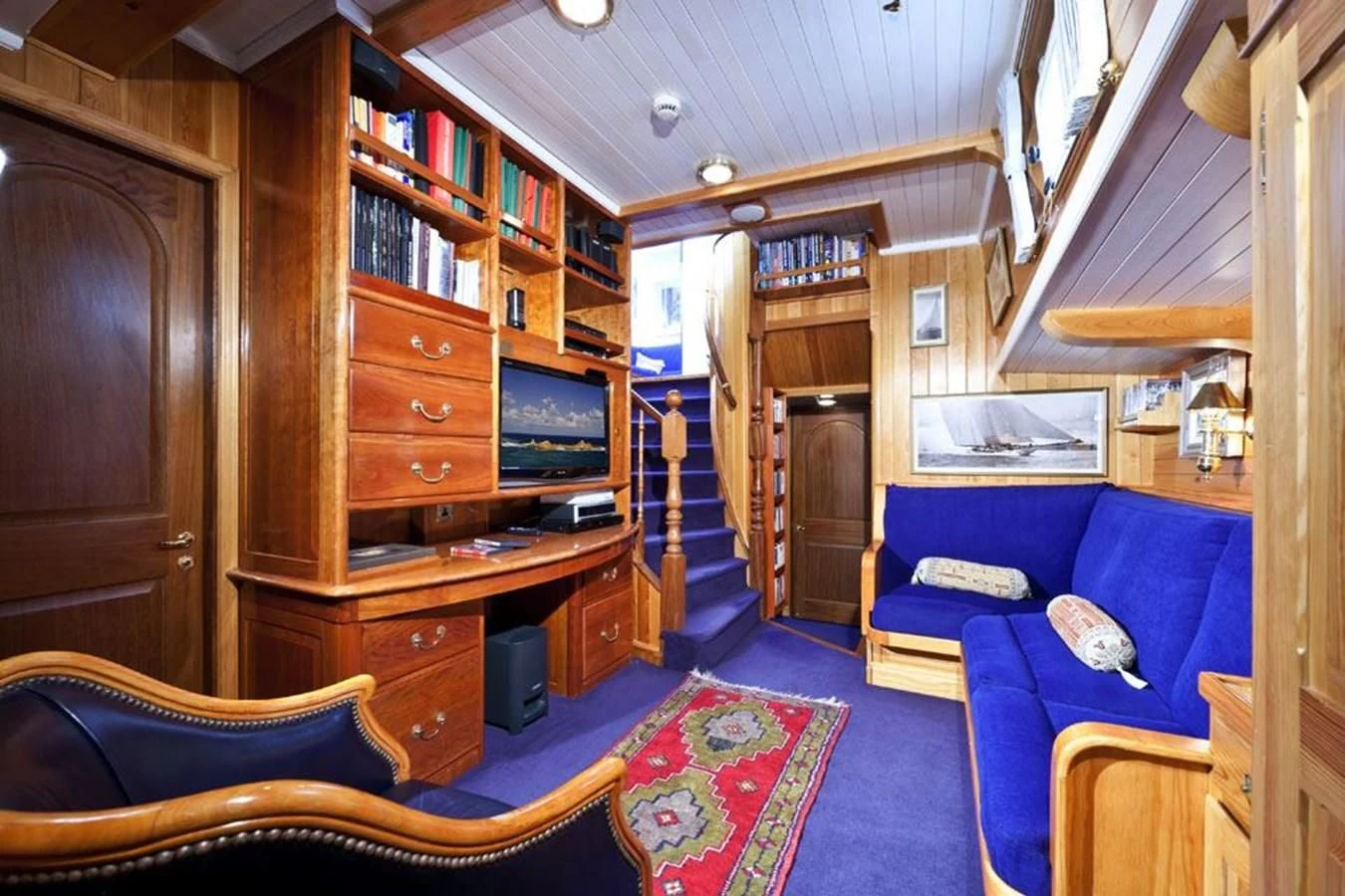 a living room with a blue couch aboard TIGERLILY OF CORNWALL Yacht for Sale