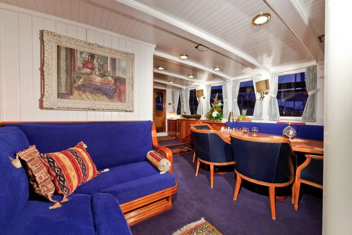 a living room with a blue couch aboard TIGERLILY OF CORNWALL Yacht for Sale