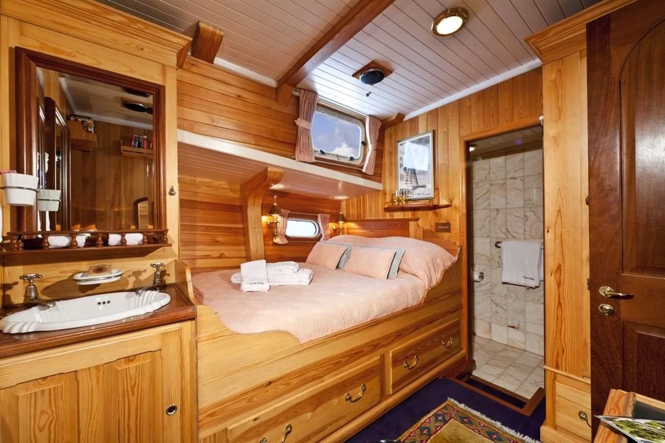 a bedroom with a bed and a mirror aboard TIGERLILY OF CORNWALL Yacht for Sale