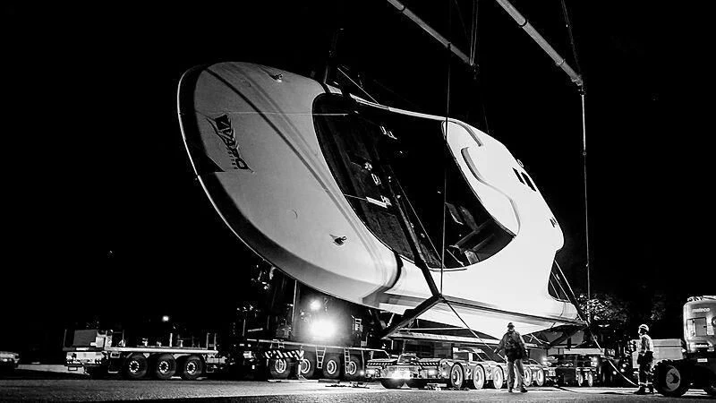 a person standing next to a large satellite dish on a stage aboard JUICE Yacht for Sale