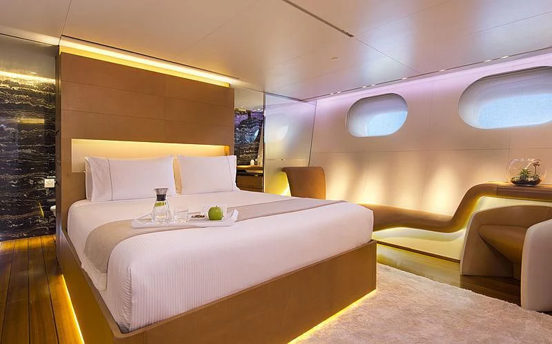 a room with a bed and a table aboard PANTHALASSA Yacht for Sale